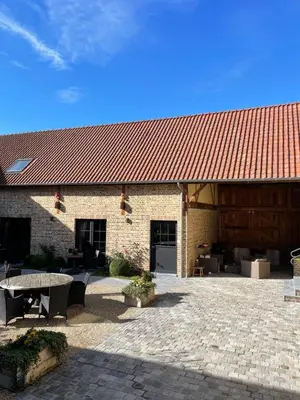 a brick building with a red roof and a patio at Hoeve Lavigne in Wellen