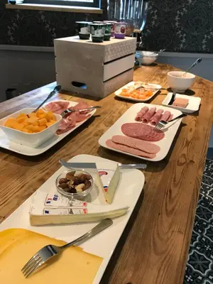 a wooden table with plates of food on it at Hoeve Lavigne in Wellen