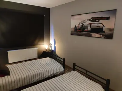 a bedroom with two beds and a picture on the wall at Gîte La Renéade in Foyr