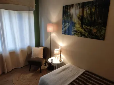 a bedroom with a bed and a chair and a lamp at Gîte La Renéade in Foyr