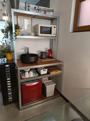 a kitchen with a shelf with a microwave on it at Loft, parking privé, terrasse, entrée indépendante in Liège