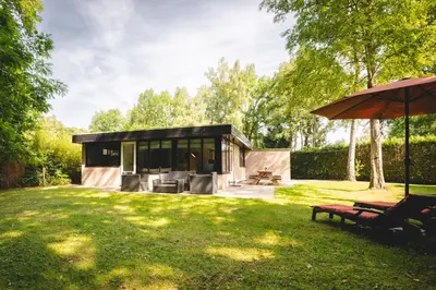a small house in a yard with an umbrella at Boshuisje Rekem - Rivus in Lanaken