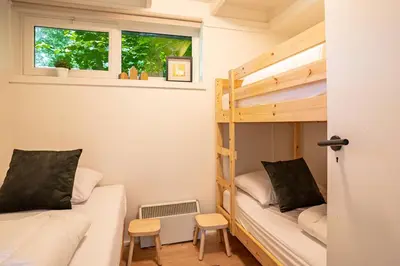 a small room with two bunk beds and a window at Boshuisje Rekem - Rivus in Lanaken