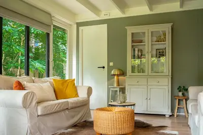 a living room with a white couch and windows at Boshuisje Rekem - Rivus in Lanaken