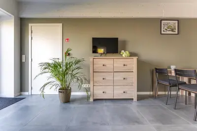 a living room with a dresser and a tv at De Hoog Velden 12 in Pelt