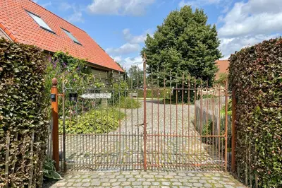 a metal gate in front of a house at B&B De Paenhoeve in Eksel