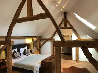 a room with a bed in the attic at B&B De Paenhoeve in Eksel