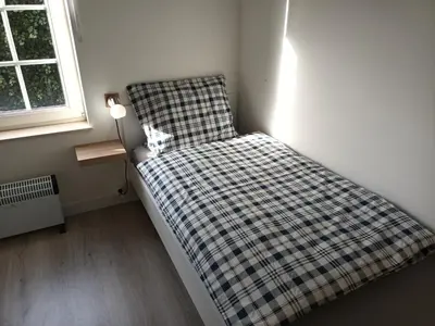a bed with a checkered blanket in a room at Kanaalzicht21 in Hasselt