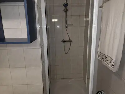 a bathroom with a shower with a glass door at Kanaalzicht21 in Hasselt