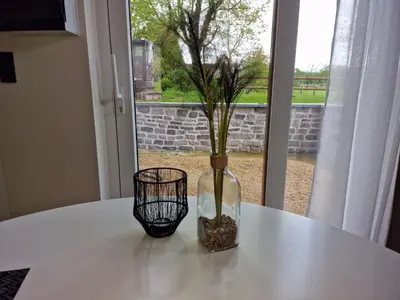 a white table with a vase with a plant in it at Gîte Eschen in Plombières