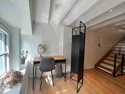 a room with a desk and a chair and a staircase at Grand Triplex d'architecte en hypercentre in Liège