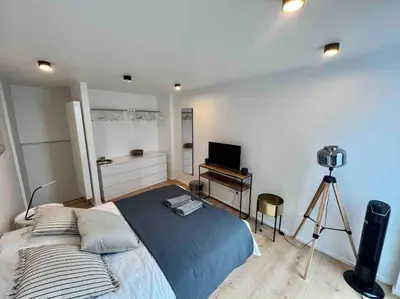 a bedroom with a bed with a camera and a desk at Triplex d'architecte en hypercentre in Liège