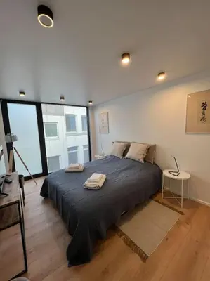 a bedroom with a large bed with two towels on it at Triplex d'architecte en hypercentre in Liège