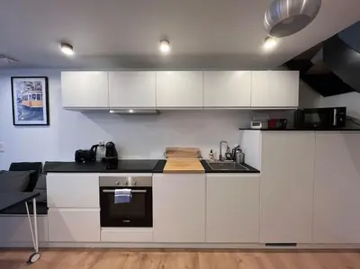 a kitchen with white cabinets and a stove top oven at Triplex d'architecte en hypercentre in Liège