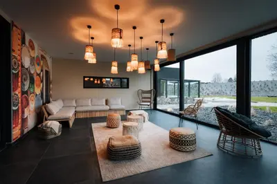 a living room with a couch and chairs and windows at Domaine des Thermes in Awans