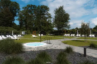 a patio with chairs and a pool in a park at Domaine des Thermes in Awans