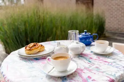 a table with cups of coffee and a pastry on it at B&B Tabibito in Genk