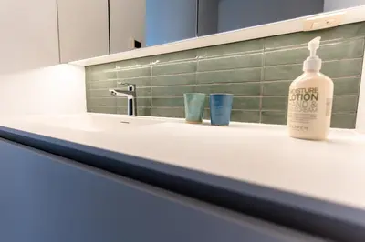a bottle of alcohol sitting on a bathroom sink at B&B Tabibito in Genk