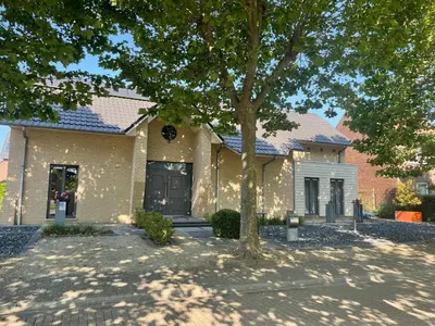 a house with a tree in front of it at Bonne Suite Chambre d'Hotes in Rekem