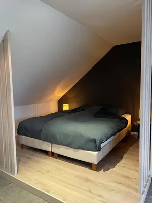 a bedroom with a large bed in a attic at Bonne Suite Chambre d'Hotes in Rekem