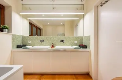 a bathroom with two sinks and a large mirror at Penthouse Hors-Château in Liège