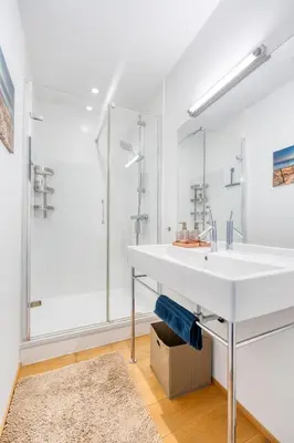 a white bathroom with a sink and a shower at Penthouse Hors-Château in Liège