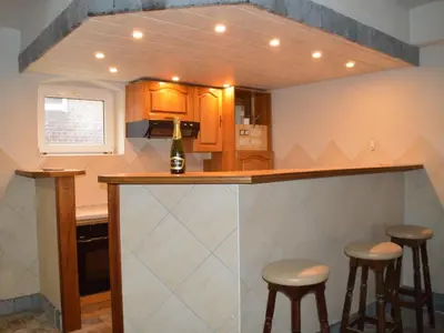 a kitchen with a bar with stools in it at Verviers Villa with Sauna in Verviers