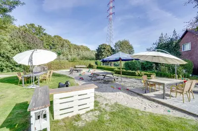 a backyard with tables and chairs and umbrellas at Franciscushof in Pelt