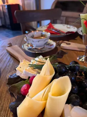 a wooden table with cheese and other foods on it at La belle Maison in Sippenaeken