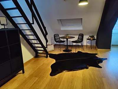 a living room with a staircase and a table and chairs at Leopold Appartementen & studio's in Sint-Truiden