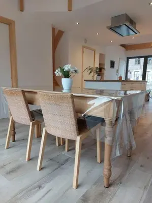 a dining room with a glass table and chairs at Aux six fontaines in Herve