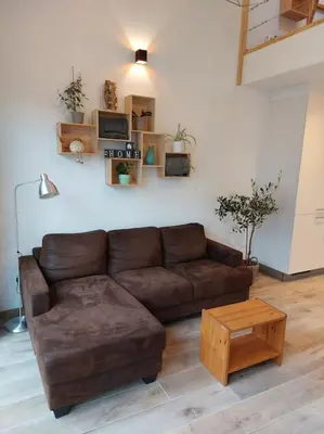 a living room with a brown couch and a table at Aux six fontaines in Herve