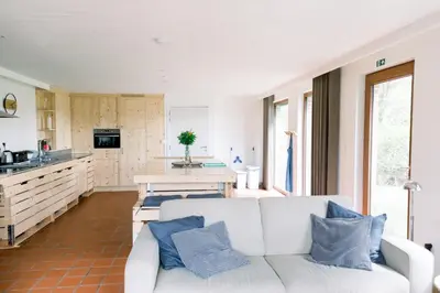 a living room with a couch and a kitchen at Lodge op de Berg in Bree