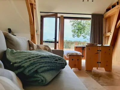 a living room with a couch and a large window at Lodge op de Berg in Bree