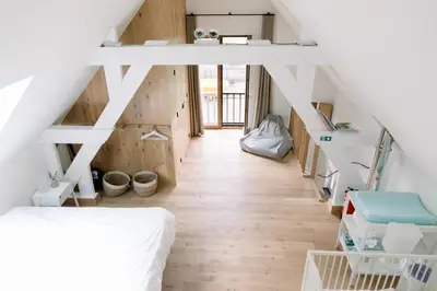 a loft bedroom with a bed and wooden floors at Lodge op de Berg in Bree