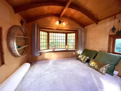 a living room with a couch and a window at Pipowagen de Kat in de Hoge Kempen nabij Maastricht in Lanaken