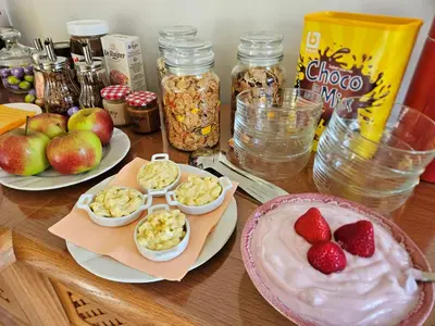 a wooden table topped with plates of food and fruit at B&B Pippa in Peer