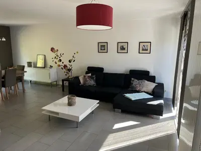 a living room with a black couch and a table at Fully furnished house, wifi, garage in Chaffours