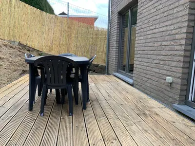 a black table and chairs on a wooden deck at Fully furnished house, wifi, garage in Chaffours