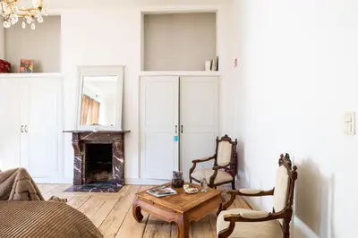 a living room with a table and a fireplace at Huis van Loon in Borgloon