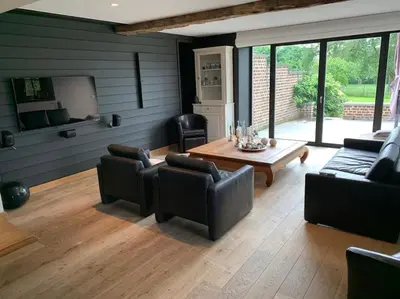 a living room with a couch and a table at Country house Clos des hortensias in Blégny