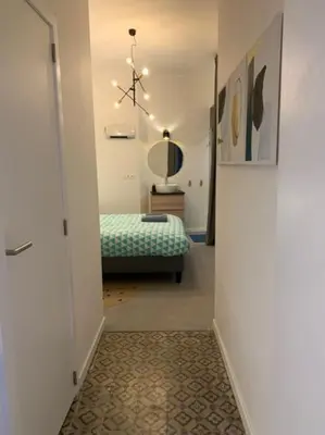 a hallway with a bedroom with a bed and a mirror at Mr White's in Liège