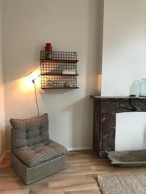 a living room with a chair and a lamp at Magnifique appartement 1ch en Outremeuse in Liège