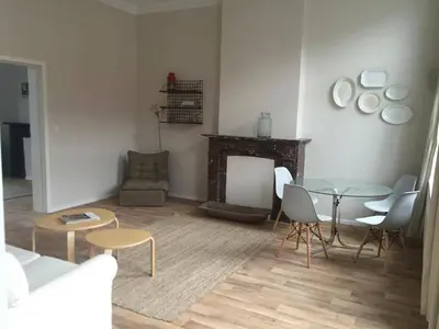 a living room with a table and chairs and a fireplace at Magnifique appartement 1ch en Outremeuse in Liège