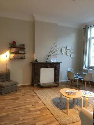 a living room with a fireplace and a table and chairs at Magnifique appartement 1ch en Outremeuse in Liège