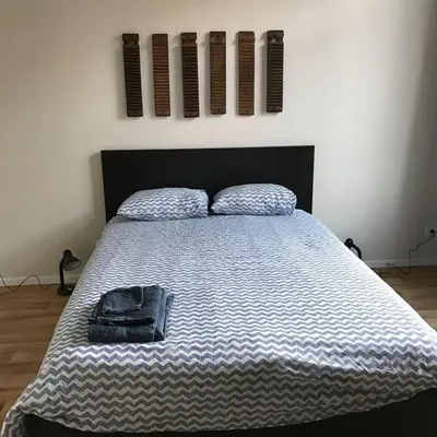 a bed with a bag sitting on top of it at Magnifique appartement 1ch en Outremeuse in Liège