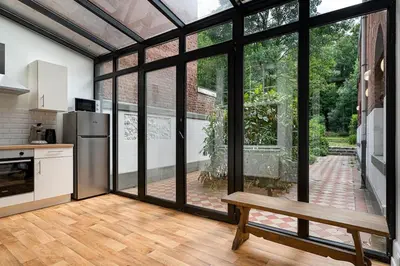 a kitchen with a refrigerator and a wooden table at Amazing appartement à Liège avec jardin in Liège