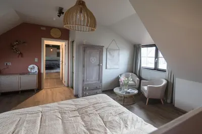 a bedroom with a bed and a desk and a table at Logies Op 't Gestel in Oudsbergen