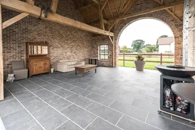 an indoor patio with a stone floor and a brick wall at Logies Op 't Gestel in Oudsbergen