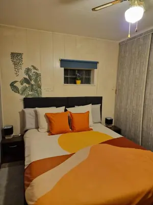 a bedroom with a large bed with orange pillows at mignon in Soumagne